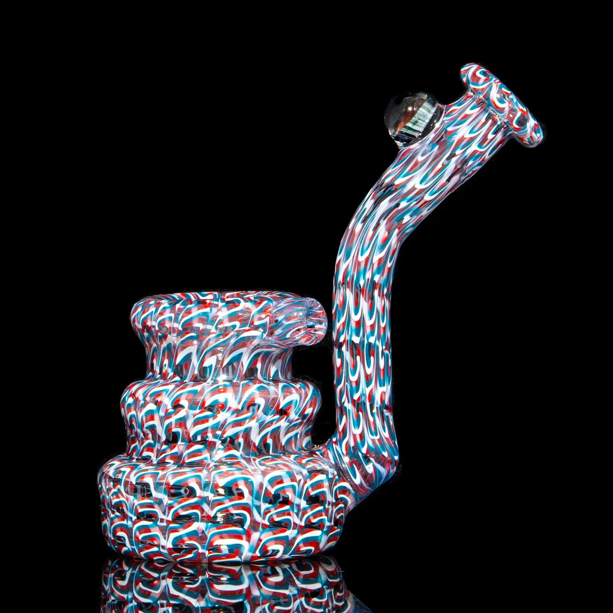 Colorful heady glass water pipe with intricate red, white, and blue swirl patterns
