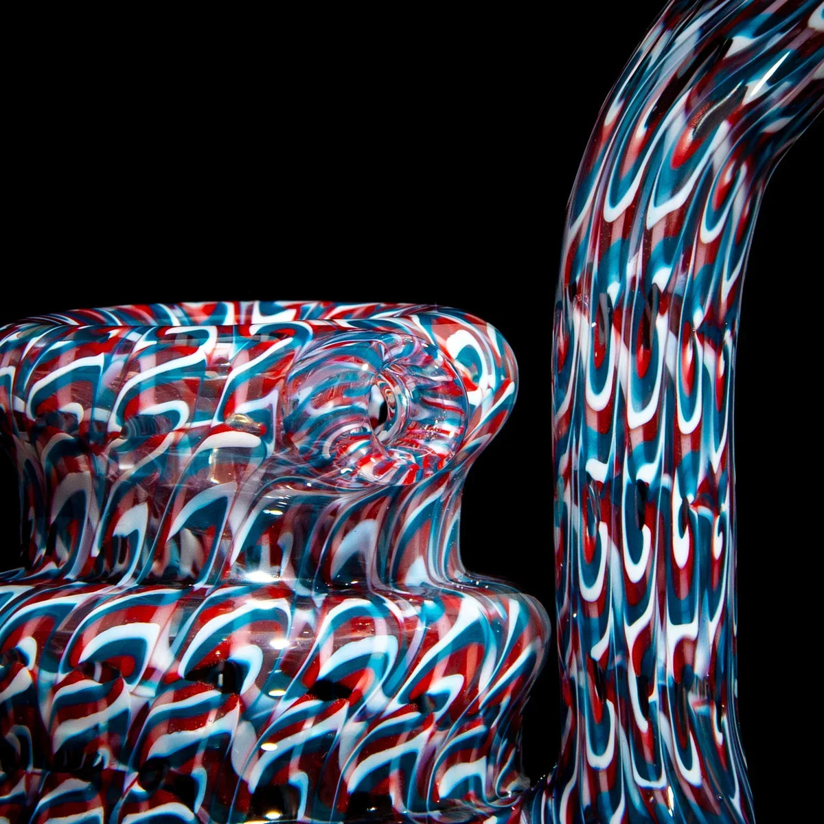 Heady glass water pipe with red, white, and blue swirl pattern on black background