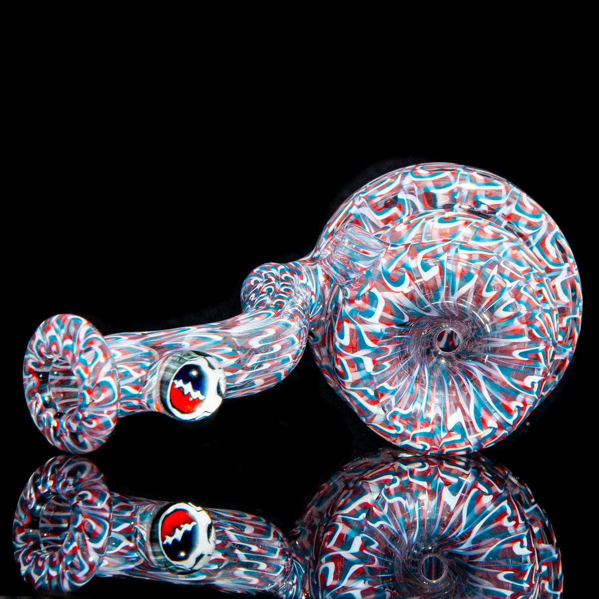 Colorful hand-blown glass pipe with red, white, and blue swirl patterns on black background