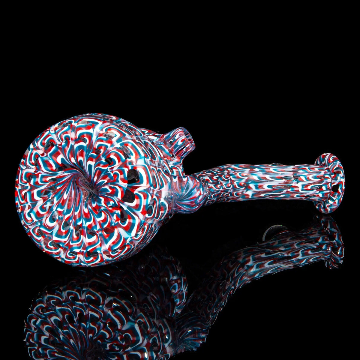 Colorful red, white, and blue glass hand pipe with intricate spiral patterns on black background.