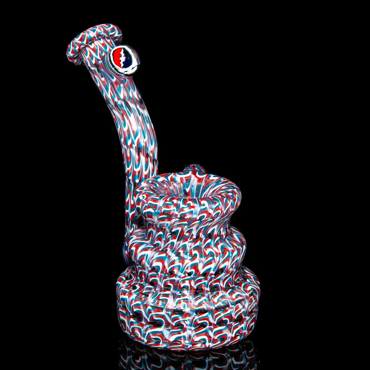 Heady glass water pipe with red, blue, and white swirl pattern on black background