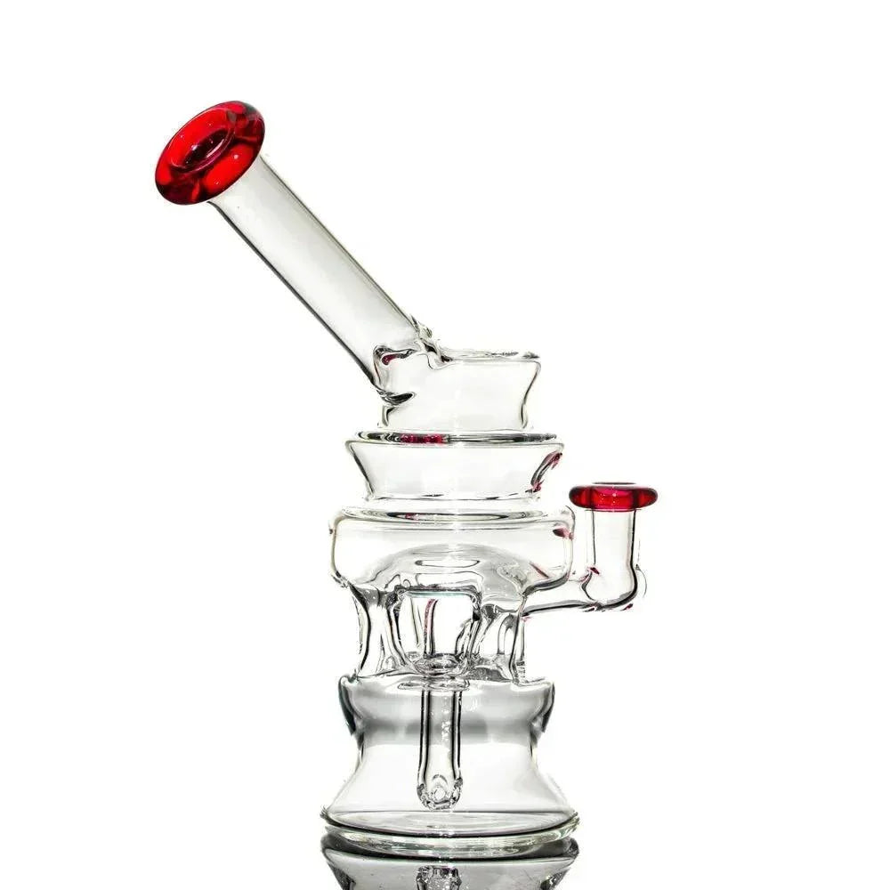Clear glass water pipe with gold ruby accents on mouthpiece and joint, isolated on white background.