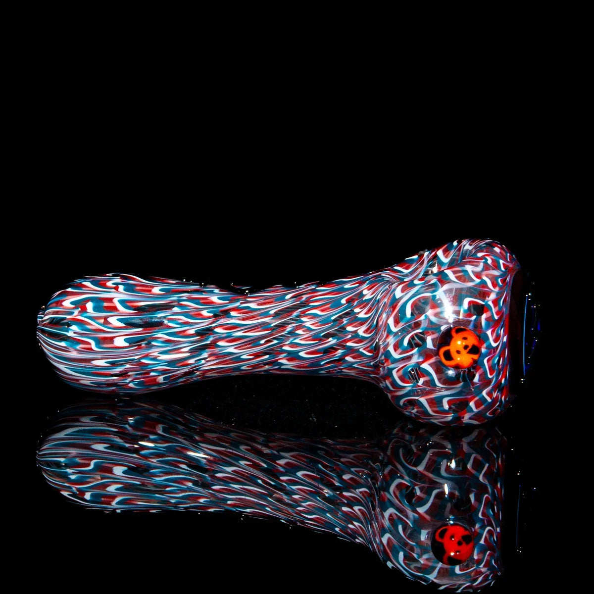 Colorful glass hand pipe with red, white, and blue swirls and a ladybug accent