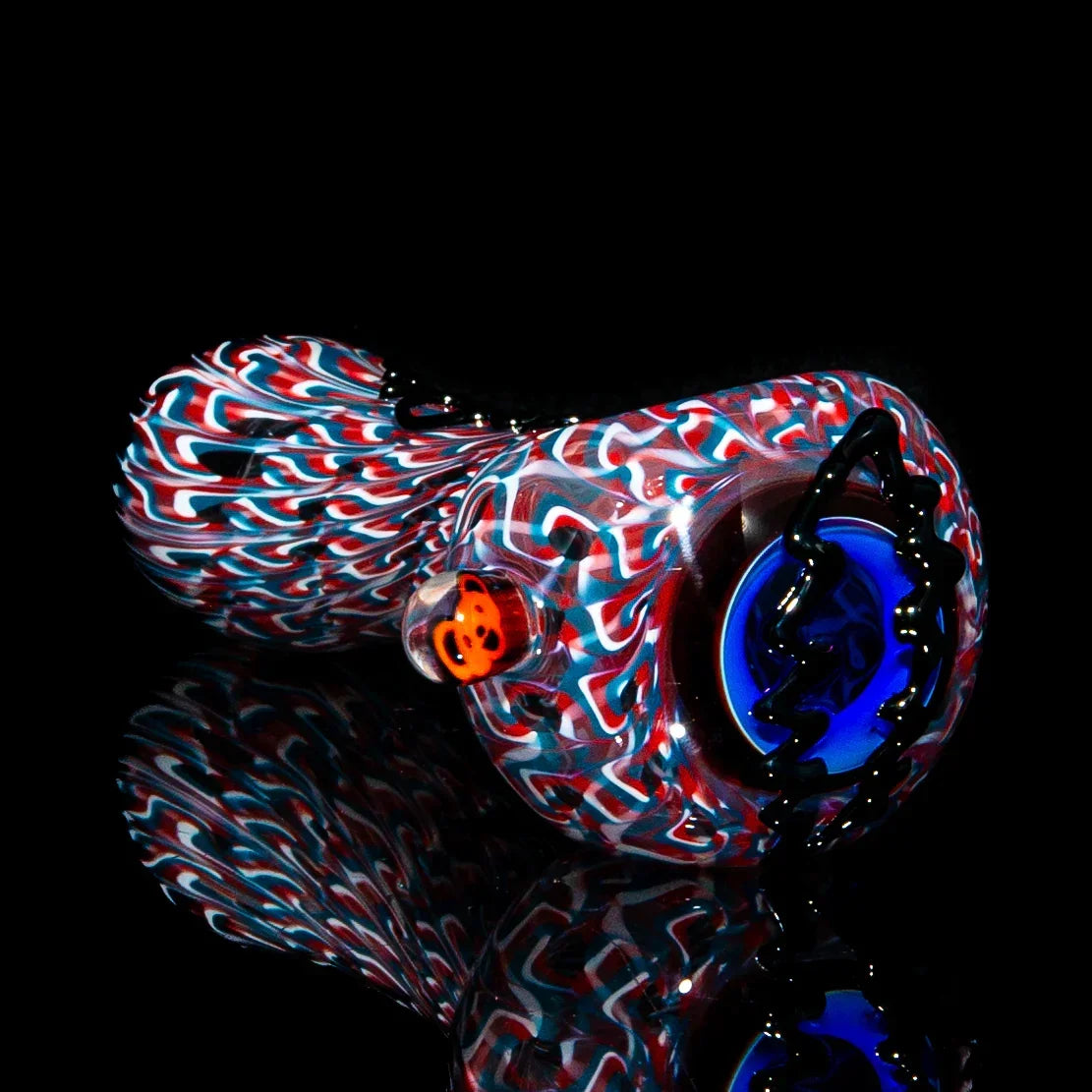 Colorful hand-blown glass pipe with swirling red, white, and blue patterns on black background