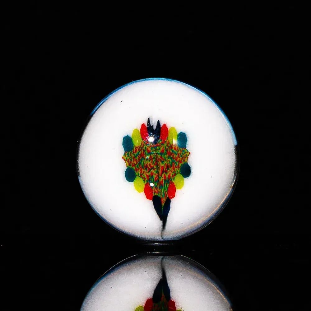 Handcrafted glass marble with colorful milli design on white base, black background