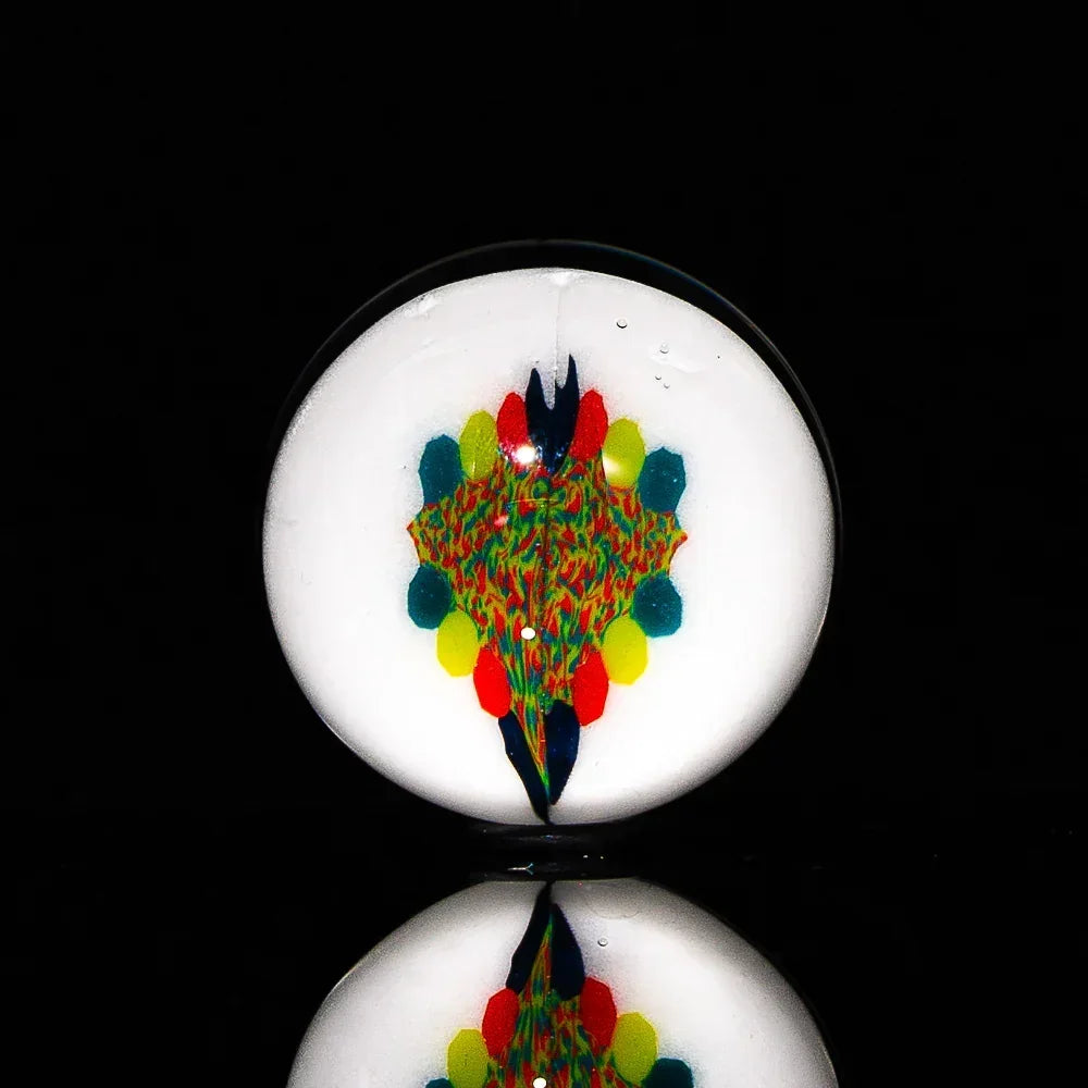 Handmade glass marble with colorful abstract design on white background, studio lighting