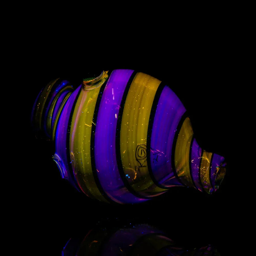 UV-reactive glass bubble cap with purple and yellow stripes on black background