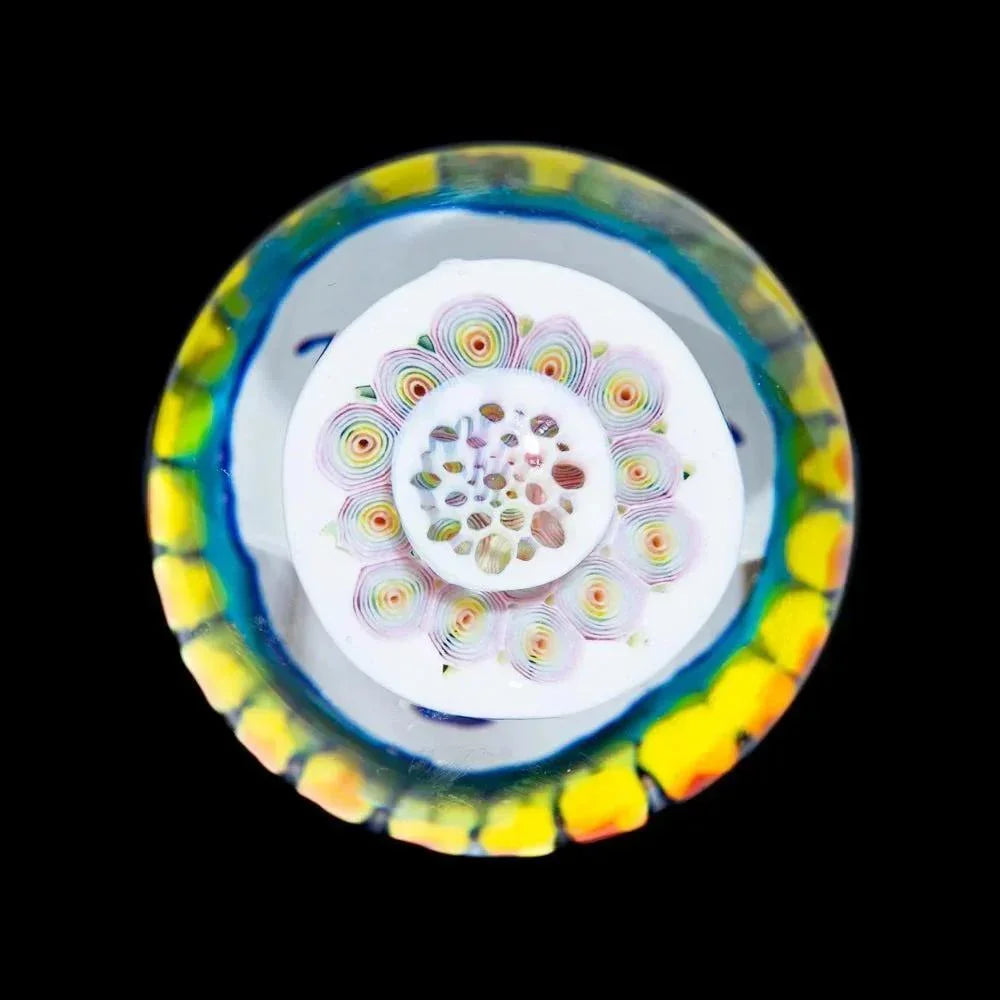 Colorful handcrafted glass marble with intricate patterns on a black background