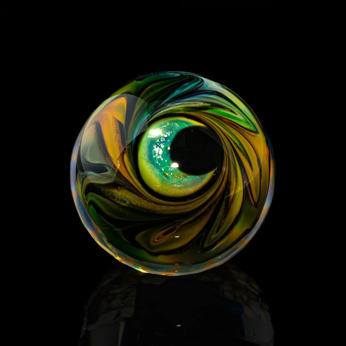 Hand-blown glass marble with vibrant green, yellow, and black swirls on a black background