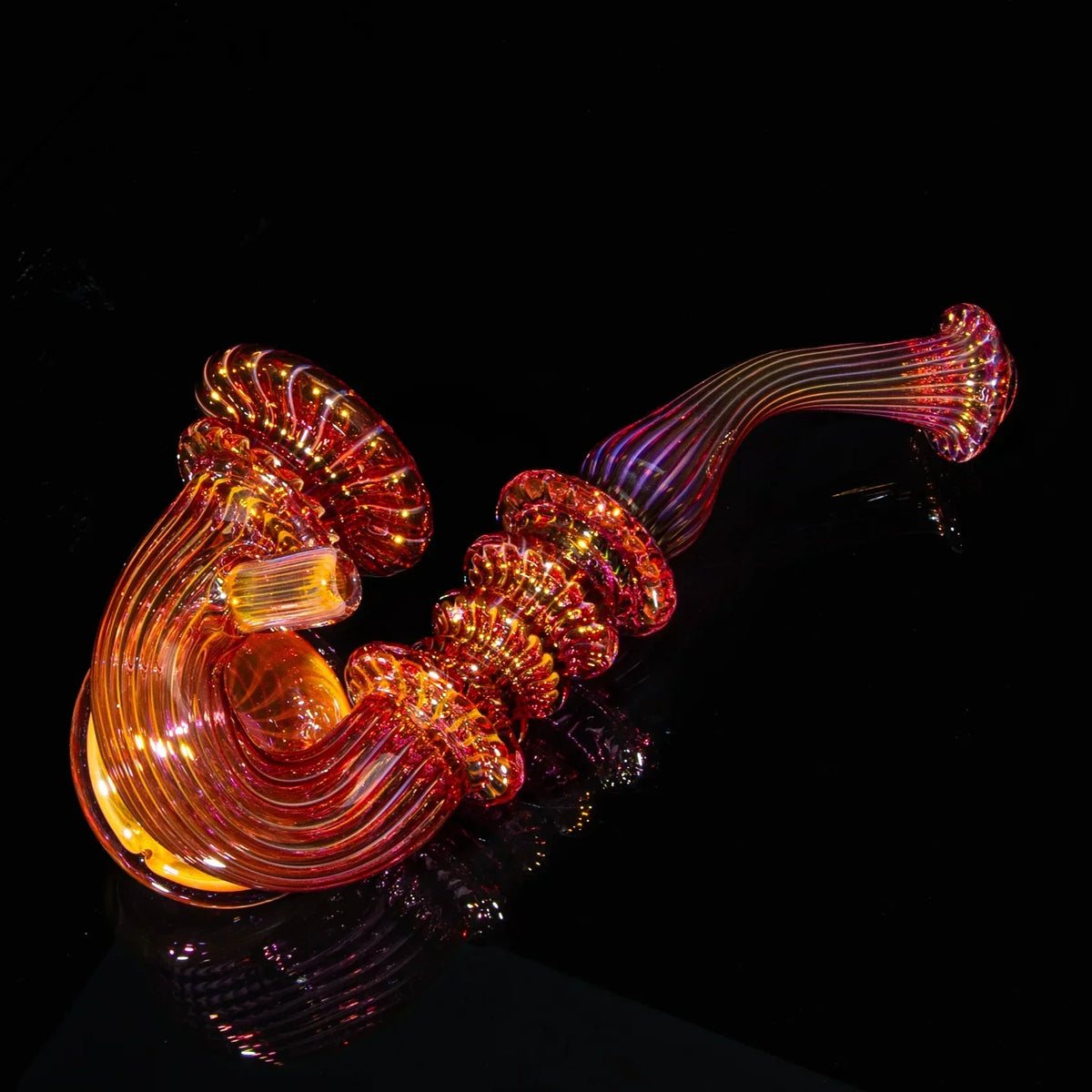 Large fumed glass sherlock pipe with intricate orange and gold details on a black background