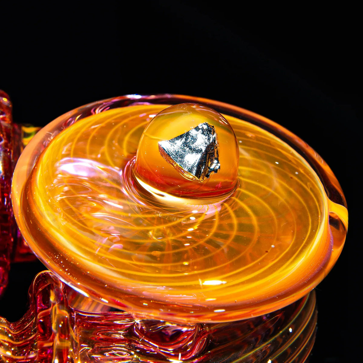 Close-up of intricate orange glass sherlock pipe with metallic accent and swirl design