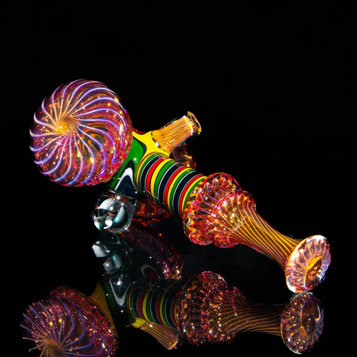 Colorful glass hand pipe with spiral fume design and rasta linework on black background