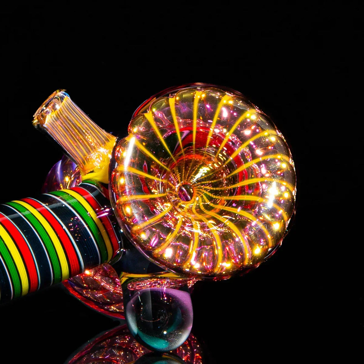 Colorful handcrafted glass pipe with spiral and striped fume design on black background