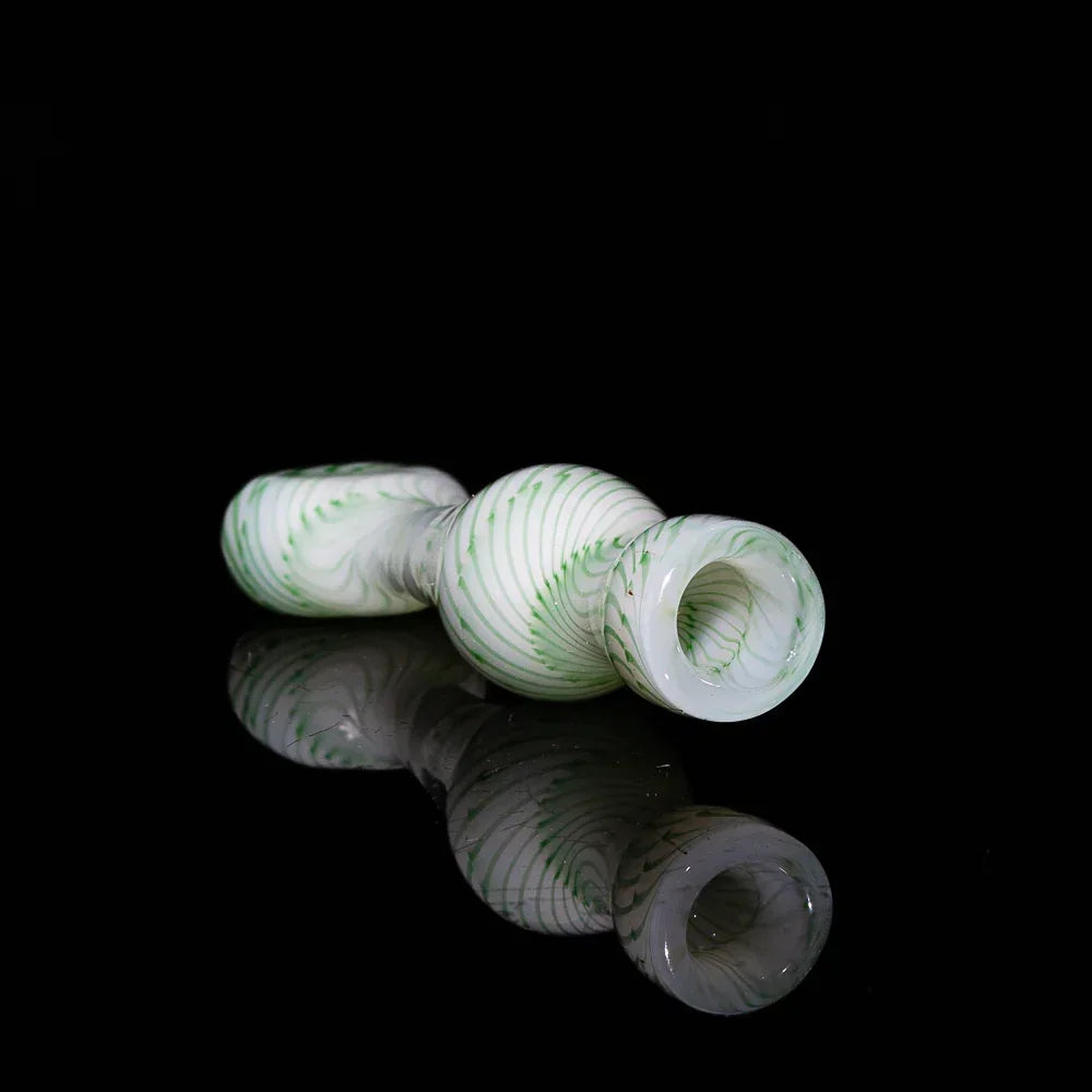White and green glass chillum pipe with spiral pattern on a black background
