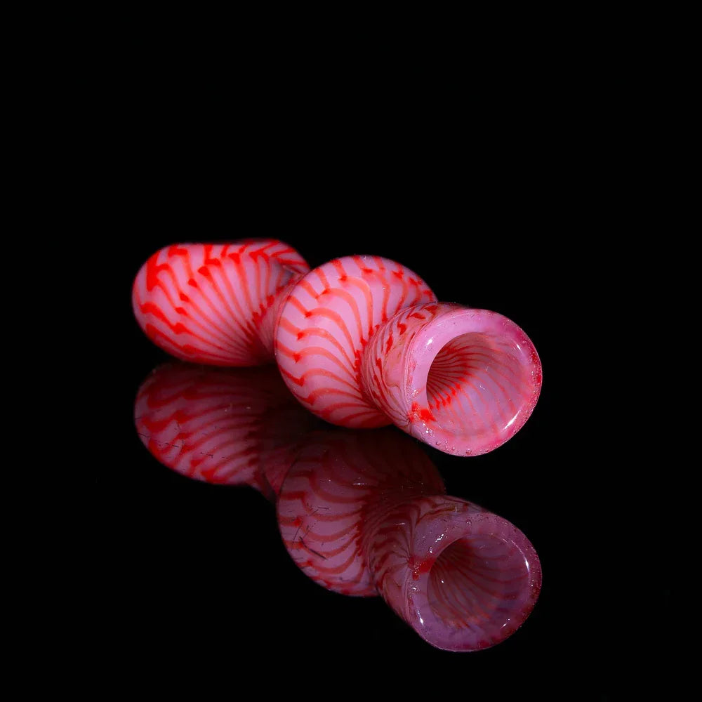 Handblown orange and red glass chillum pipe with spiral coil design on black background