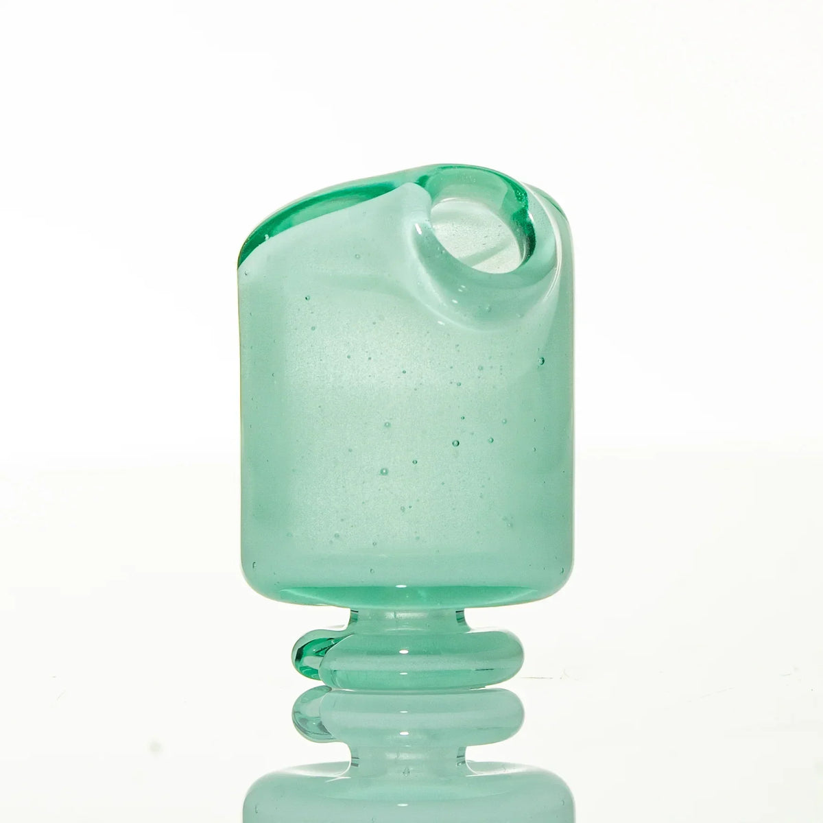 Translucent mint green glass mouthpiece with a rounded base and angled opening on a white background.
