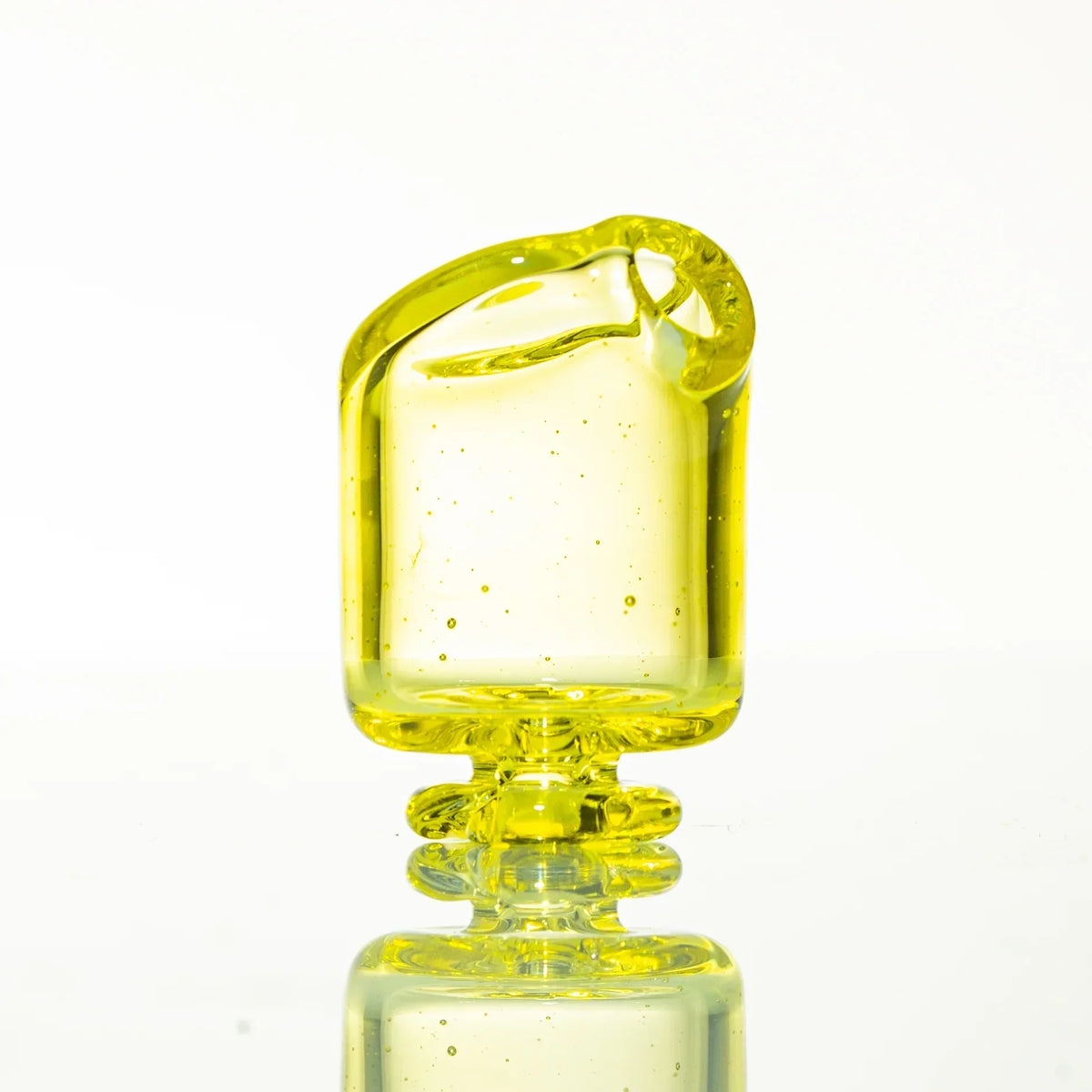 Yellow glass pivot mouthpiece with pearl set, displayed on a reflective surface