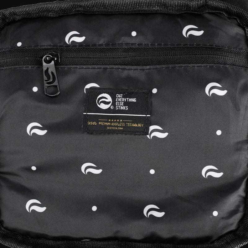 Black accessory pouch interior with white logo pattern, zipper pocket, and branded tag.