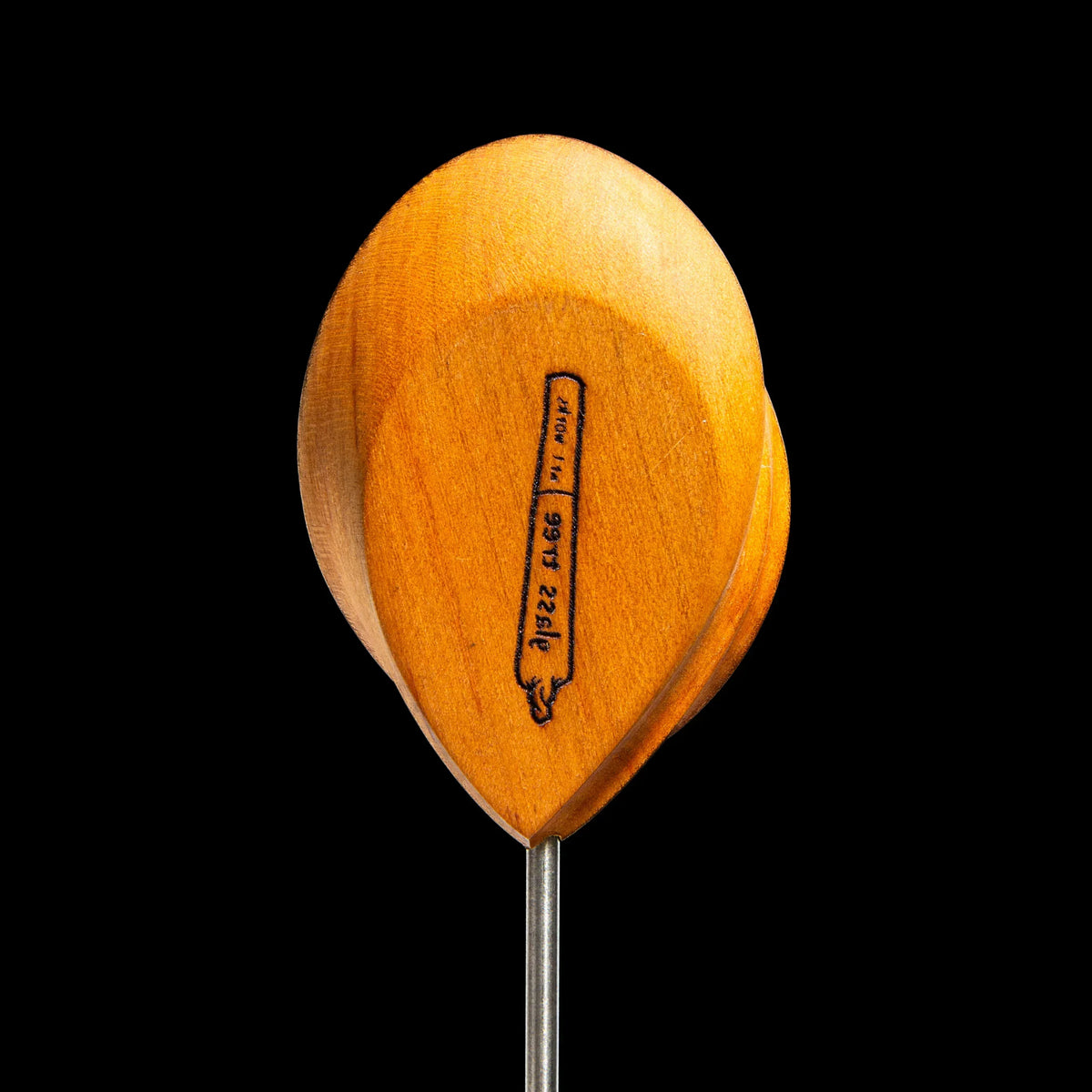 Wooden dab tool with engraved design and metal tip on black background