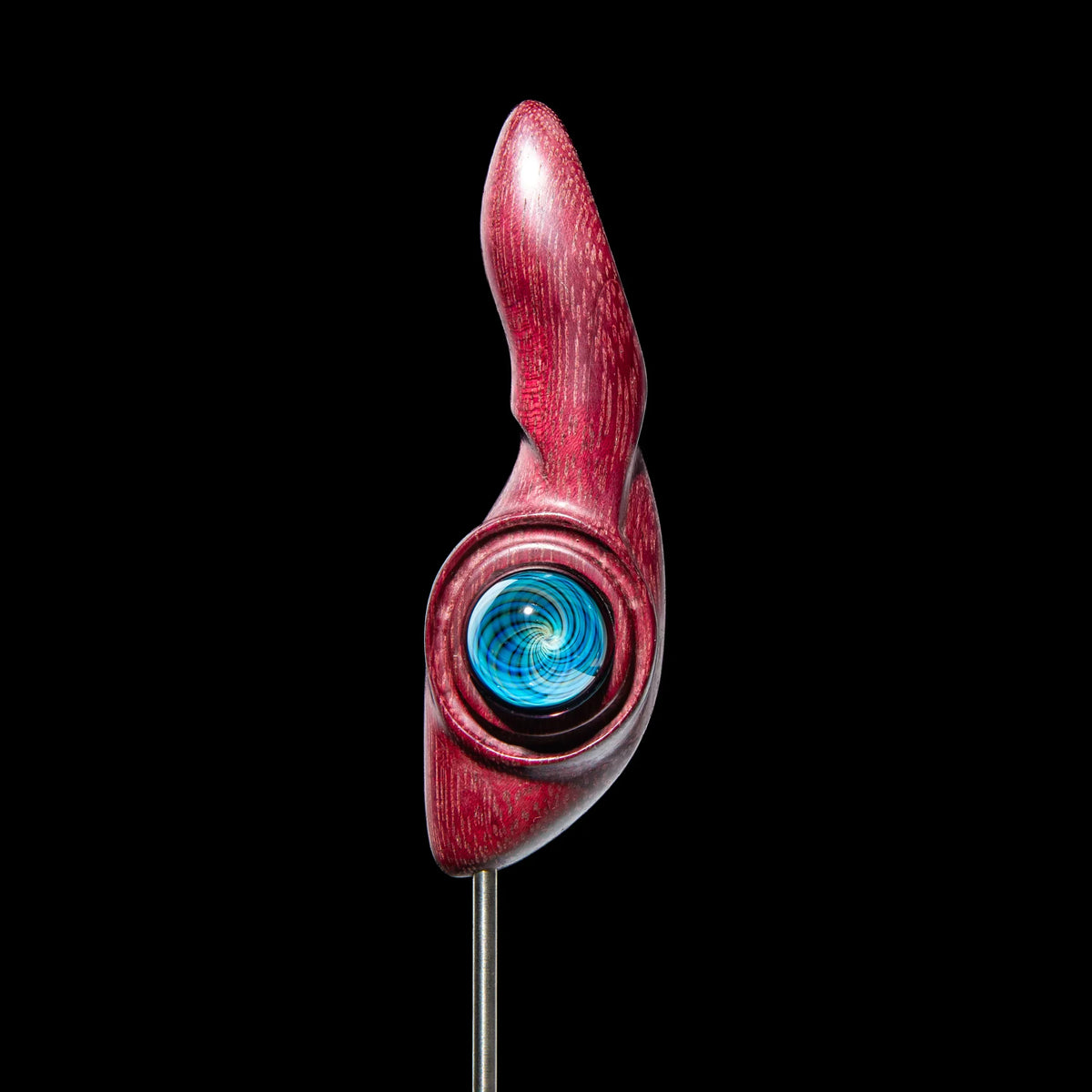 Red glass dab tool with blue swirl accent on black background