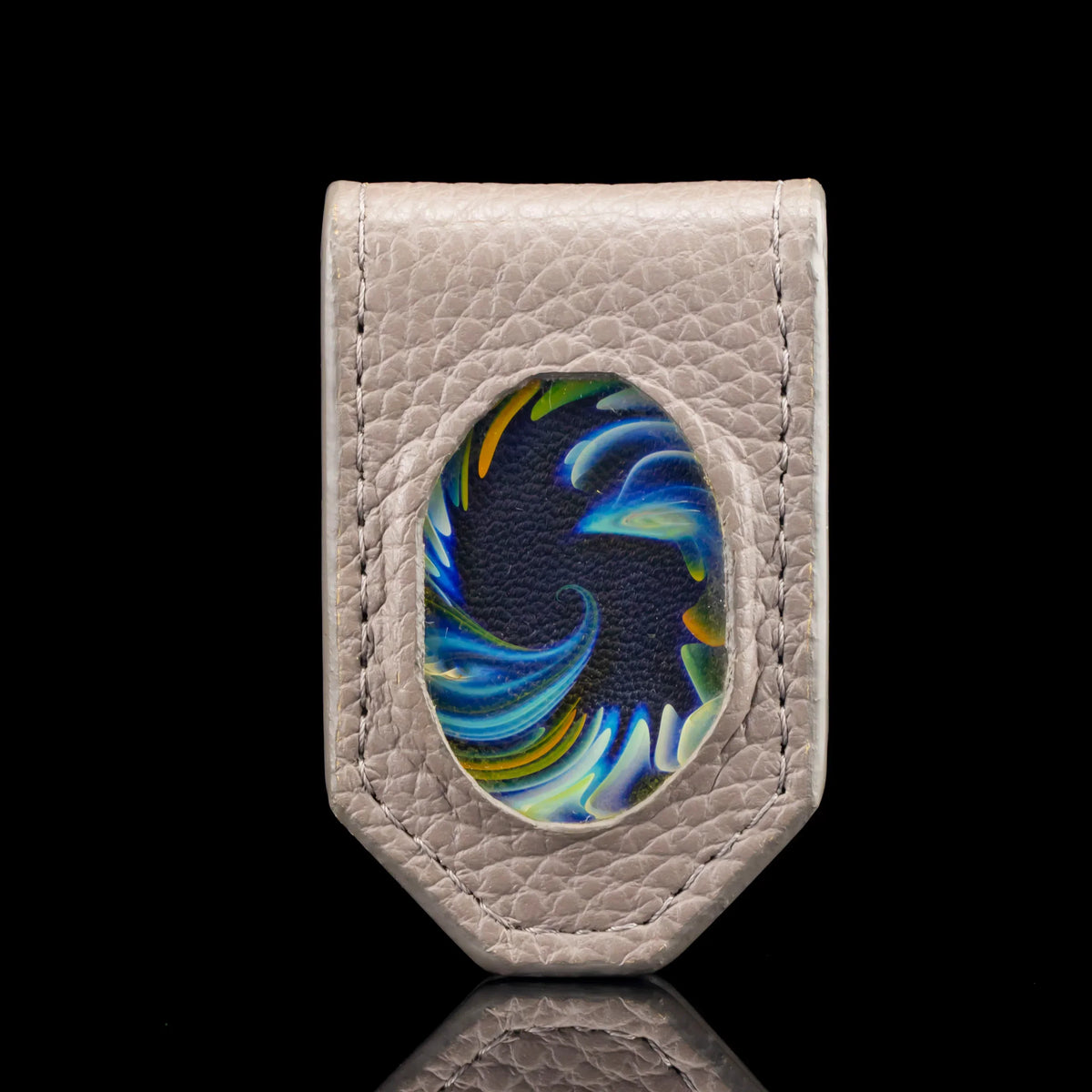 Textured leather money clip with colorful glass inlay, displayed on black background