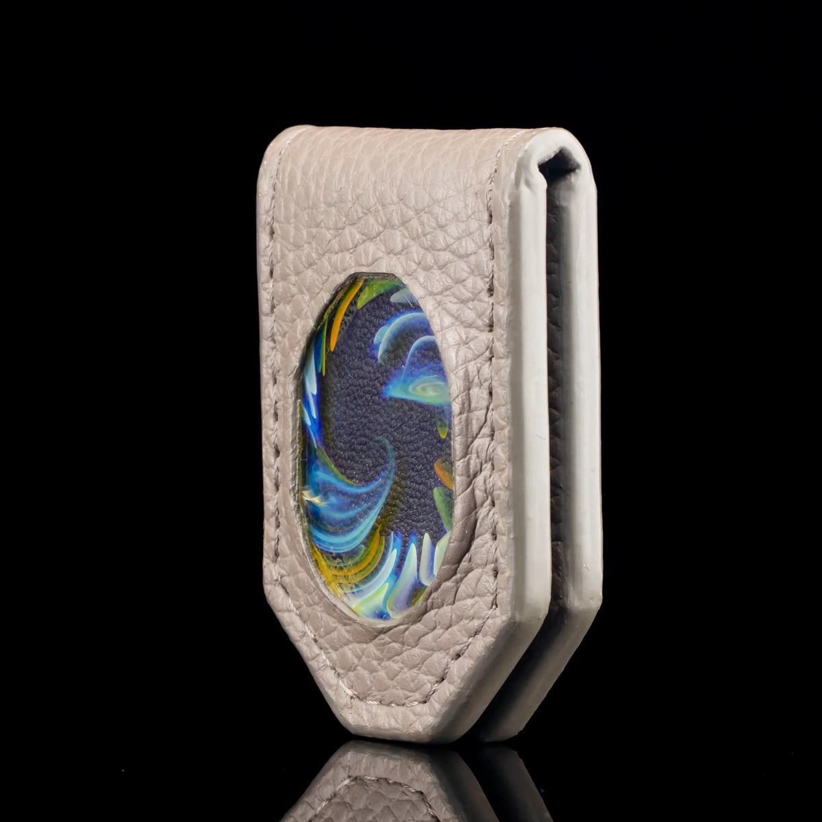 Leather money clip with colorful glass inlay, textured surface, isolated on black background