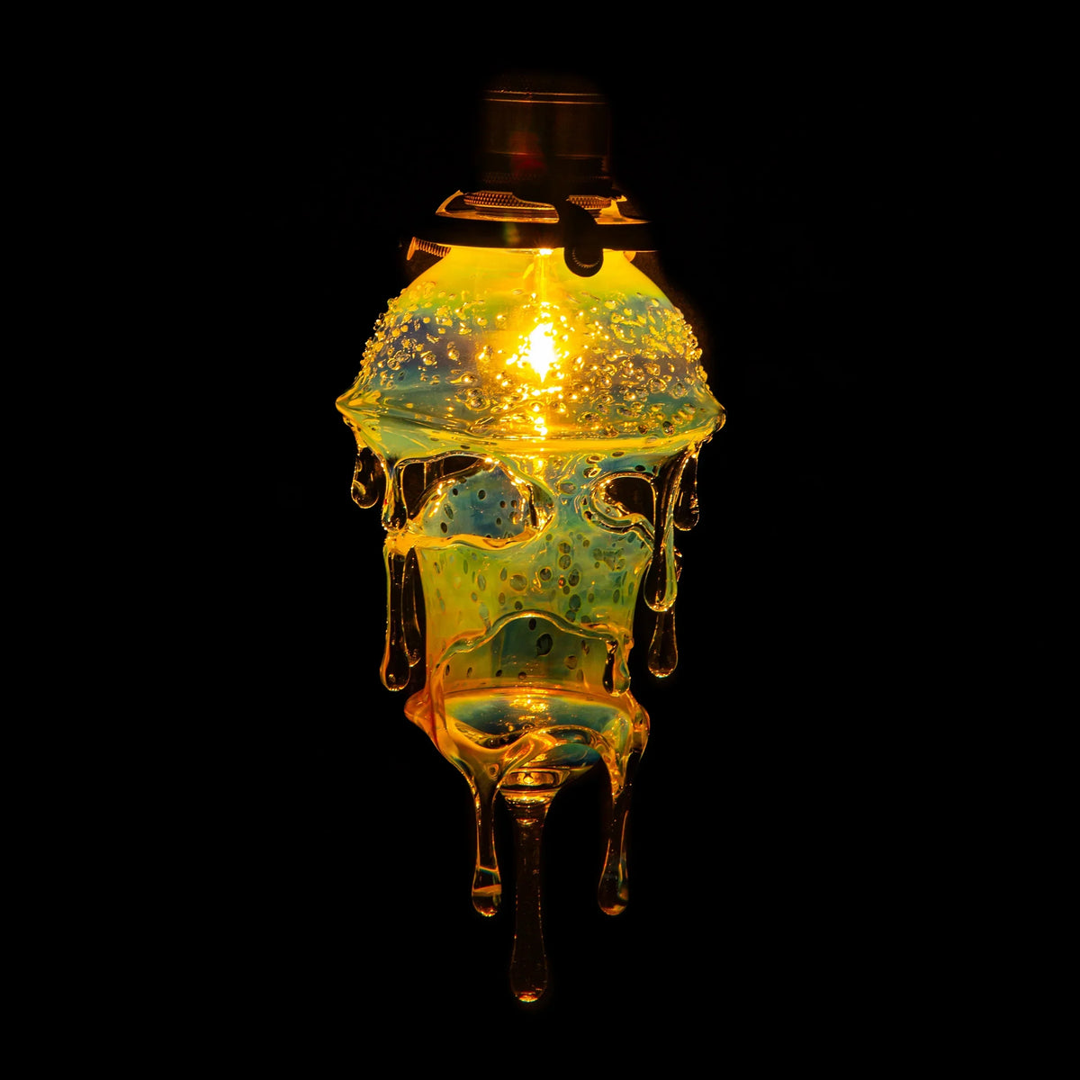 Hand-blown glass drip lamp with glowing yellow light and artistic melting effect