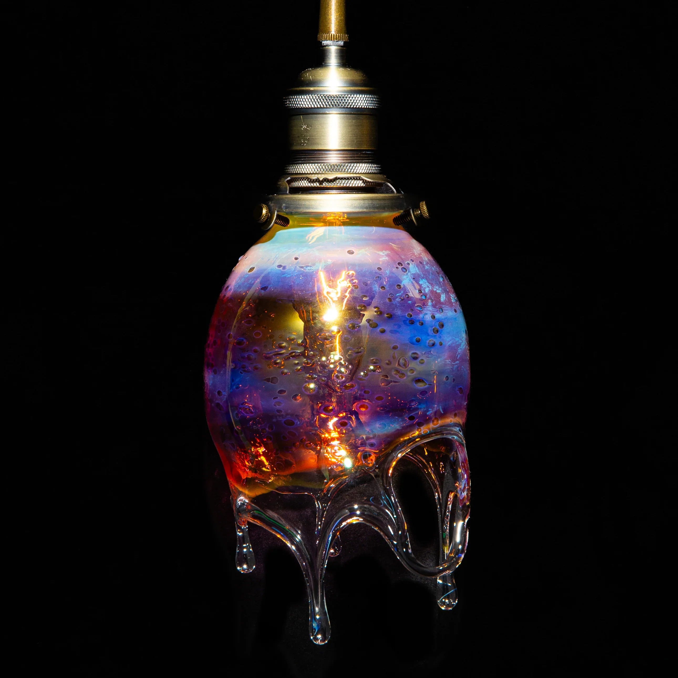 Colorful blown glass pendant lamp with drip design and iridescent hues on black background