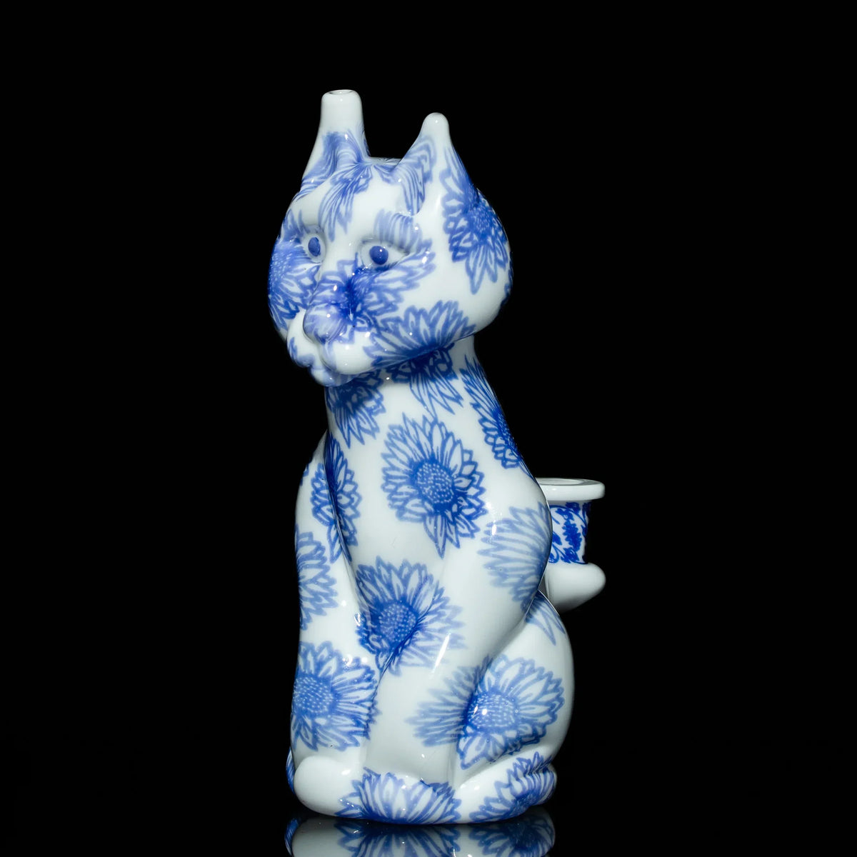 Ceramic cat water pipe with blue floral patterns on white, displayed on black background
