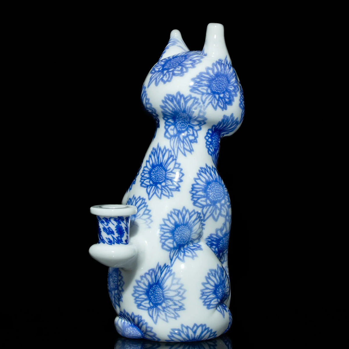 Blue and white cat-shaped glass pipe with sunflower pattern on black background