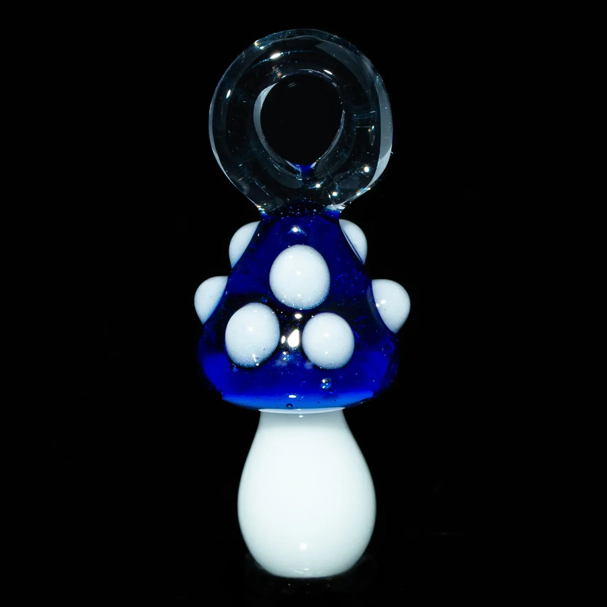 Cobalt blue glass mushroom pendant with white spots on a black background
