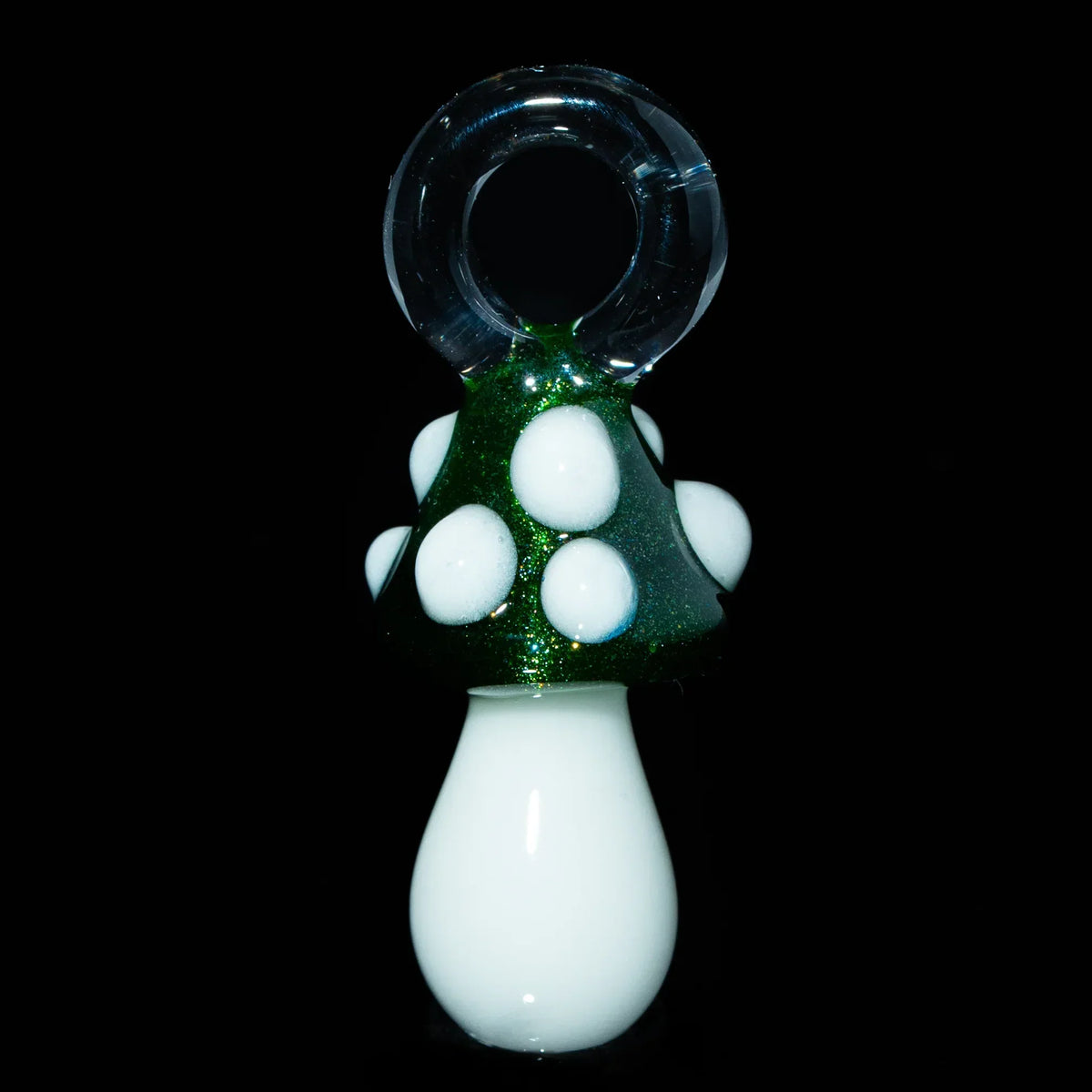 Green mushroom glass pendant with white spots and a clear glass loop on black background