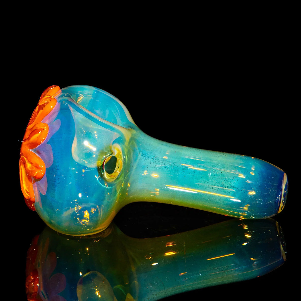 Blue glass spoon pipe with orange and purple flower design, displayed on black background