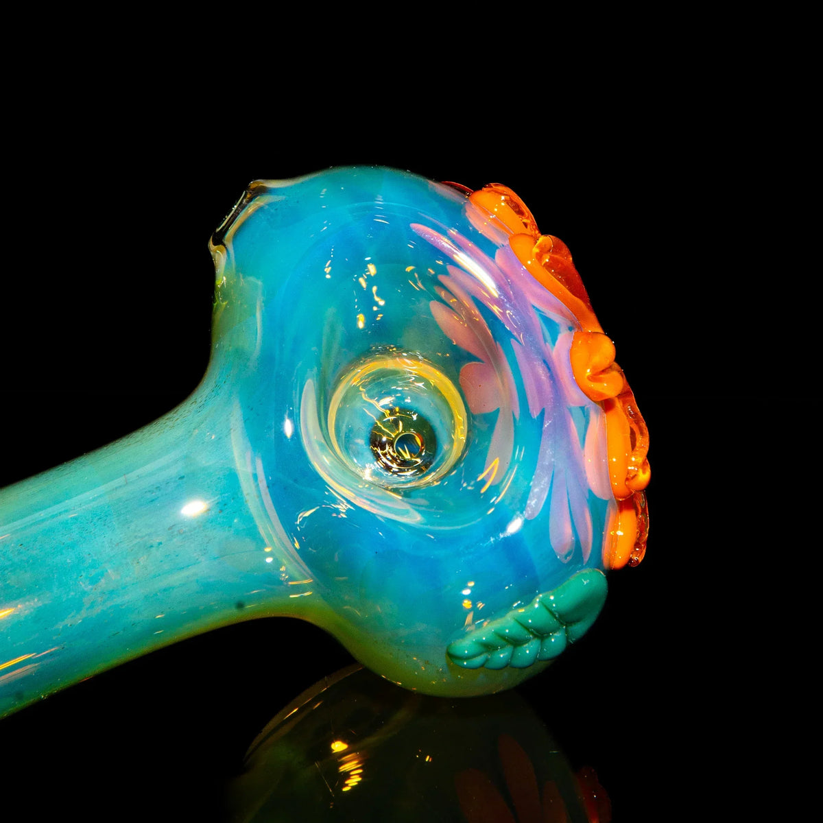 Colorful glass spoon pipe with orange wildflower design on a black background