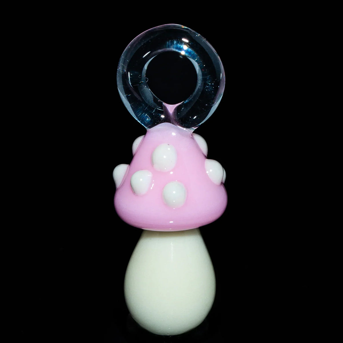 Handcrafted pink mushroom glass pendant with white spots on a black background