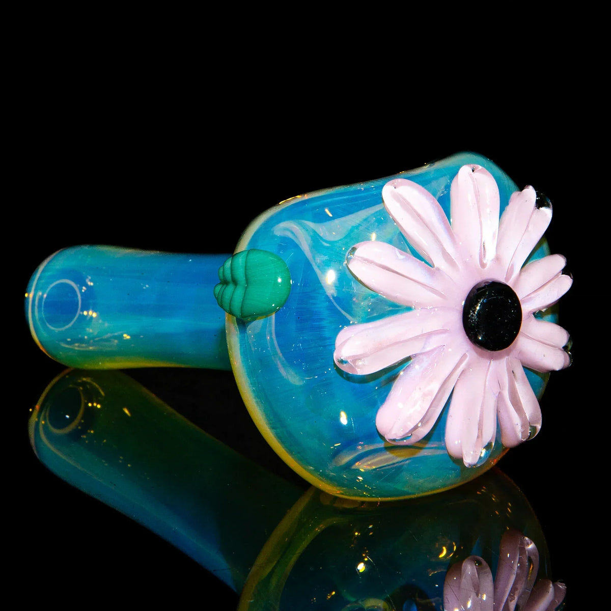 Blue glass spoon with pink wildflower design and green accent, displayed on black background