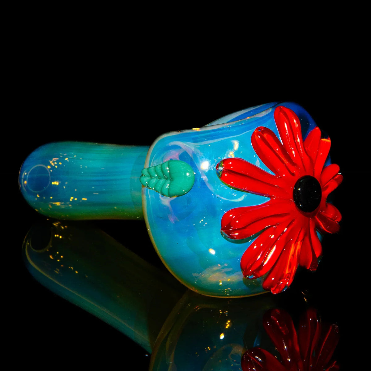 Blue glass hand pipe with red flower accent and green detail, displayed on black background