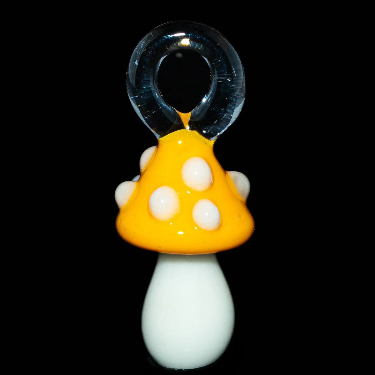 Yellow glass mushroom pendant with white spots on black background
