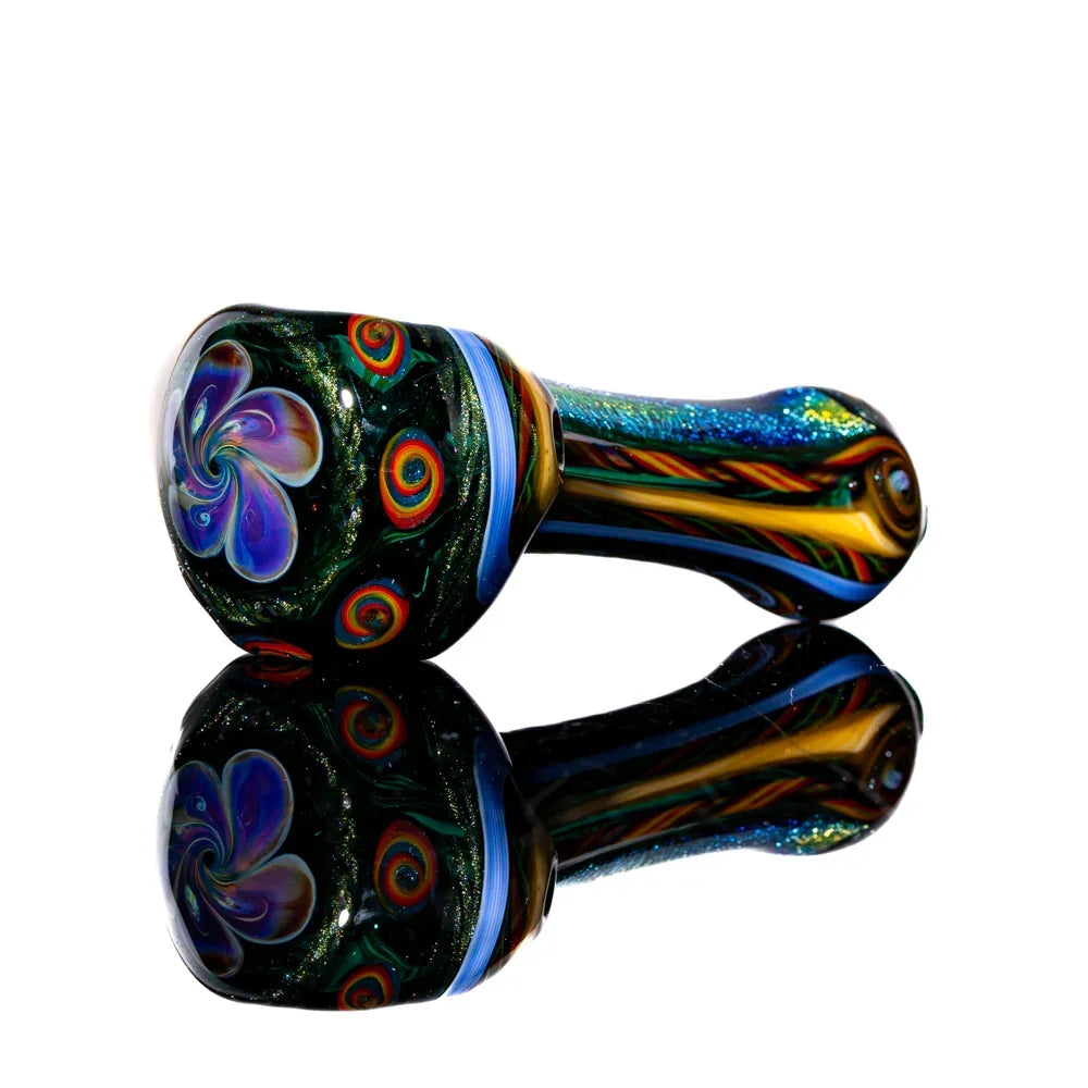 Colorful glass hand pipe with blue, yellow, and swirling rainbow designs on reflective surface