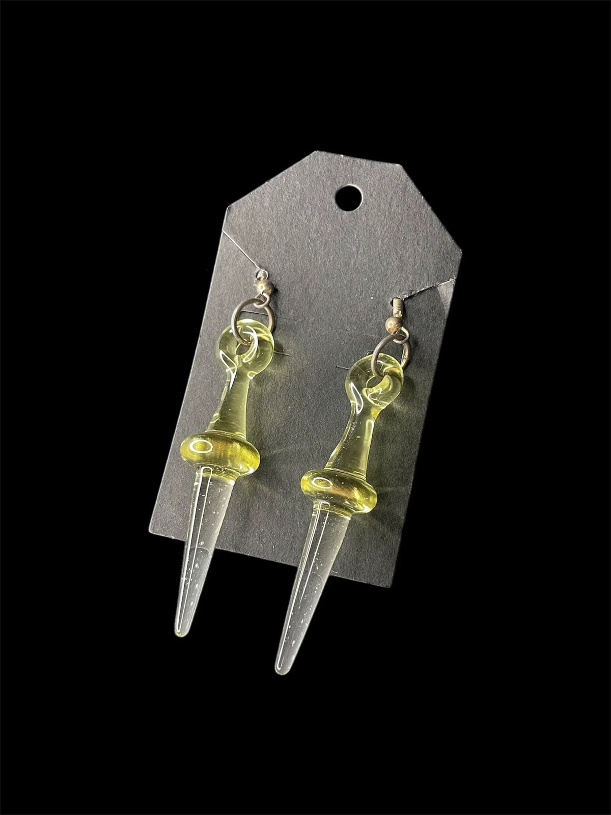Handmade glass earrings with yellow-tinted elongated drop design on black tag