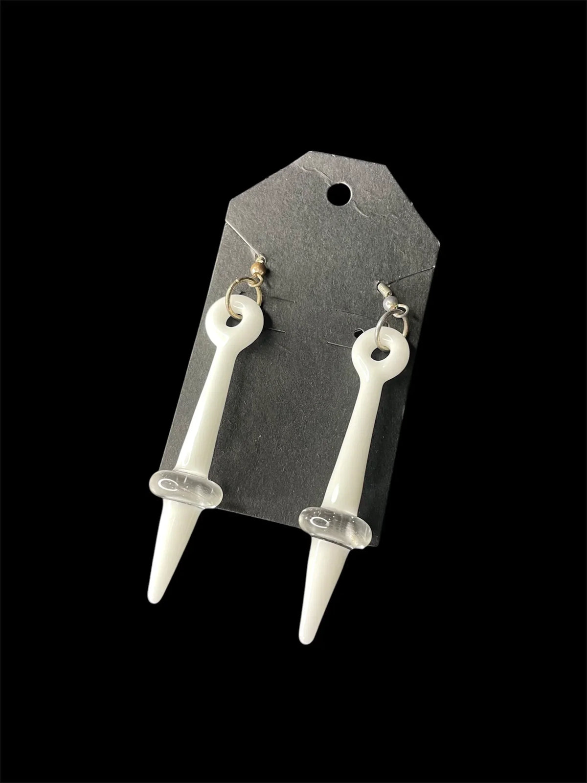 White glass spike earrings with clear accents on black display card, jewelry product photo