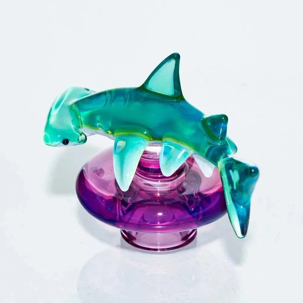 Colorful glass shark carb cap with purple base, heady glass smoking accessory on white background.