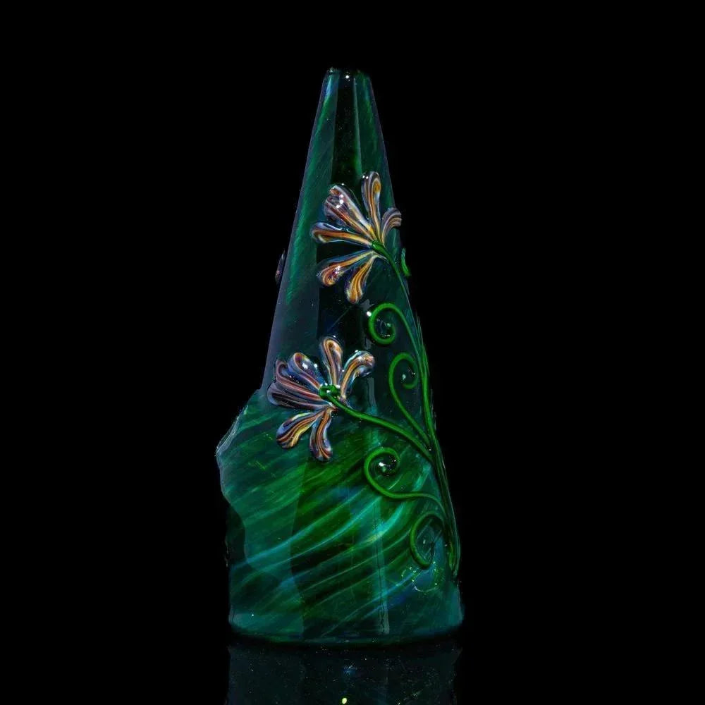 Green glass water pipe with intricate floral design on dark background