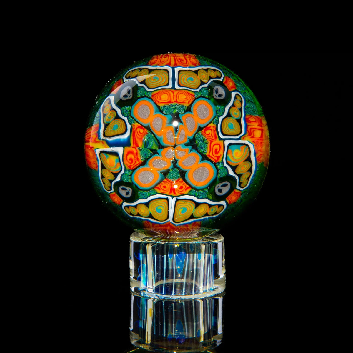Colorful psychedelic art glass marble with intricate geometric patterns on clear stand