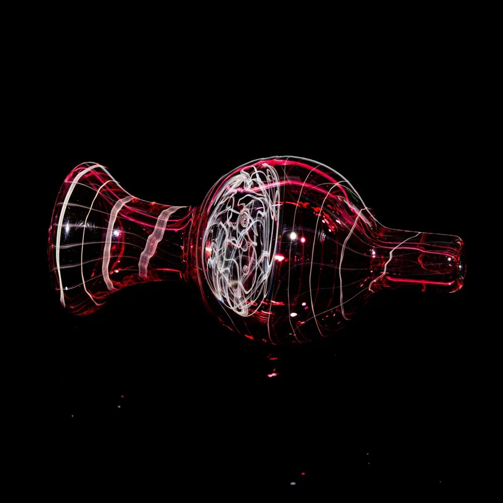 Gold and ruby glass bubble cap with swirl design on black background