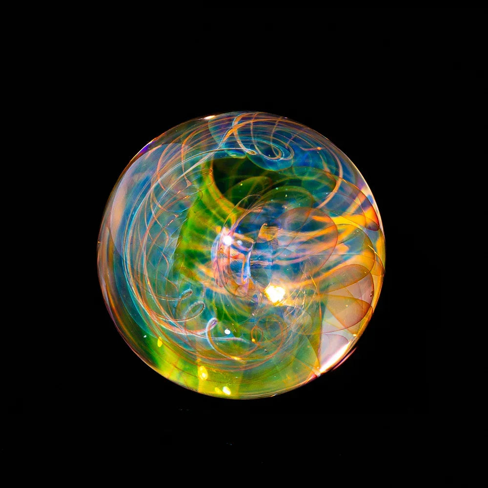 Colorful heady glass marble with intricate swirling patterns on black background