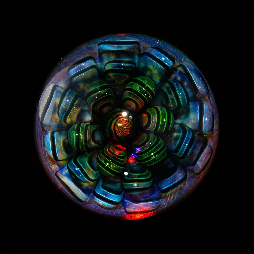Colorful heady glass marble with intricate spiral and flower pattern on black background