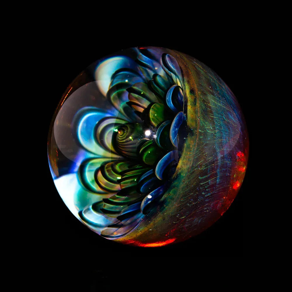 Colorful handmade glass marble with intricate floral design on black background