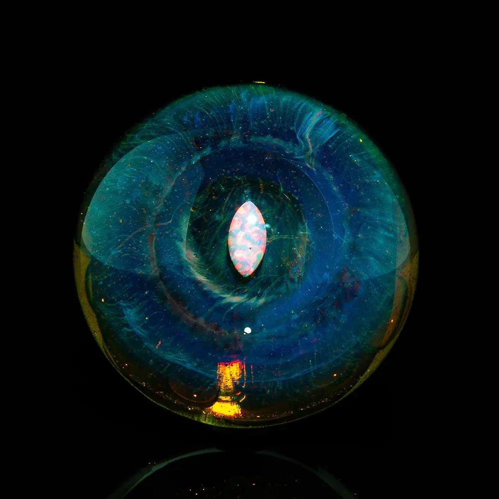 Close-up of a colorful heady glass marble with opal center on black background