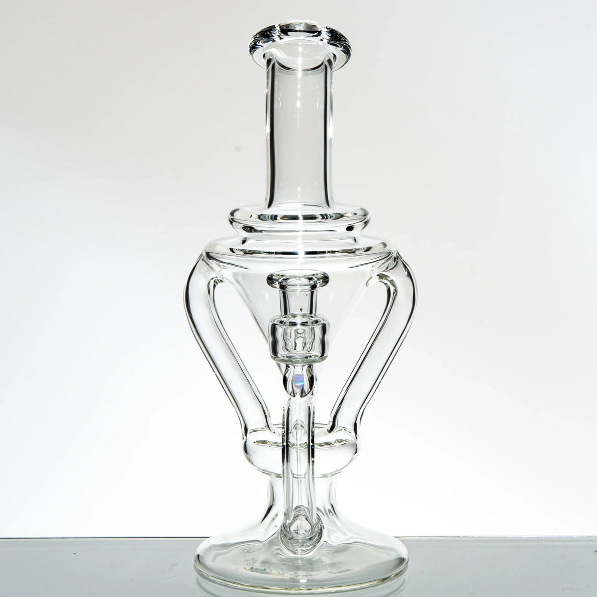 Clear glass recycler water pipe with intricate double uptake design on white background